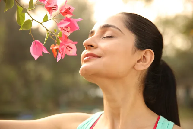 small-vecteezy_a-lovely-female-is-smelling-flowers-in-a-garden_69500796_small